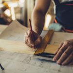 Contractor measuring a wood plank for a remodeling project